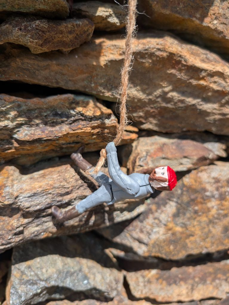 Jacques, in a red beanie, climbing some rocks